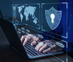 Man working on laptop showing a map of the world and a security shield